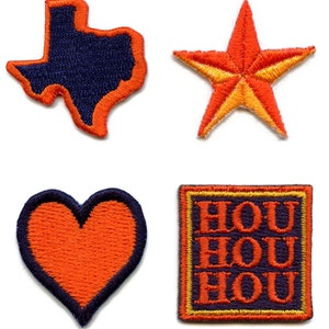 May include: Four embroidered iron-on patches in various shapes and colors. The patches include a blue Texas outline, a yellow and orange star, a red heart, and a purple square with the word "HOU" repeated three times.