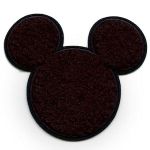 May include: A brown felt Mickey Mouse head applique with black stitching around the edges.