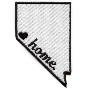 Könnte beinhalten: Gestickter Aufnäher in Form von Nevada, mit schwarzem Rand. Der Aufnäher zeigt ein schwarzes Herz und das Wort "home" in Schreibschrift.