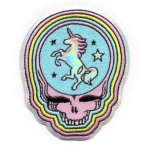 May include: An embroidered patch featuring a holographic unicorn inside a skull with a rainbow halo. The unicorn is surrounded by stars.