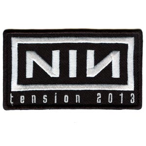 May include: Black and white embroidered patch with the word "NIN" in a white box and the text "tension 2013" below.