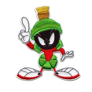 May include: An embroidered iron-on patch featuring a cartoon character with a green hat, red shirt, and black face. The character is standing with one arm raised and a finger pointing up. The character is known as Marvin the Martian.