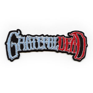 May include: Embroidered patch featuring the words "Grateful Dead" in a stylised font. The word "Grateful" is in light blue and the word "Dead" is in red.