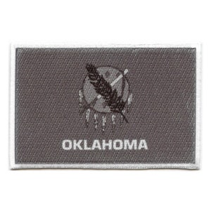 May include: A grey fabric patch with a white border. The patch features a black and white image of a Native American symbol with a feather and the word "OKLAHOMA" in white text.