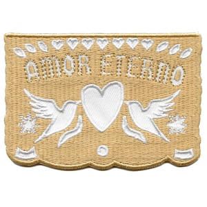 Könnte beinhalten: Ein beigefarbener gestickter Aufnäher mit einem weißen Herzen und zwei weißen Tauben. Der Text "AMOR ETERNO" ist in Weiß gestickt.