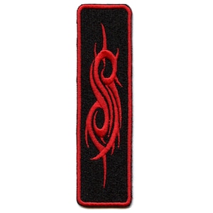 Può includere: Toppa ricamata rossa con un design stilizzato a forma di "S" su sfondo nero. La toppa ha un bordo rosso.
