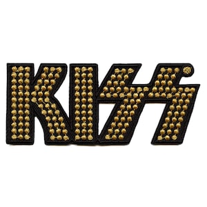May include: Black and gold embroidered KISS logo patch. The letters are outlined in black and filled with gold sequins.