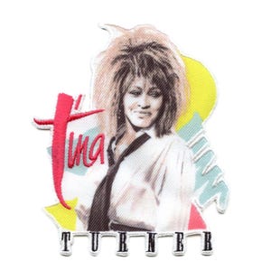 Könnte beinhalten: Ein weißer und rosa gestickter Aufnäher mit einem Porträt von Tina Turner, ihrer Unterschrift in Rot und dem Text "TURNER" in Schwarz.