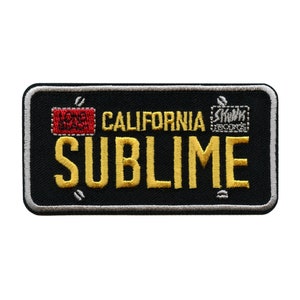 May include: Black and white embroidered patch with the text "CALIFORNIA SUBIME" in yellow. The patch also features a red and white square with the text "1995" and a gray square with the text "SHOCK RECORDS".