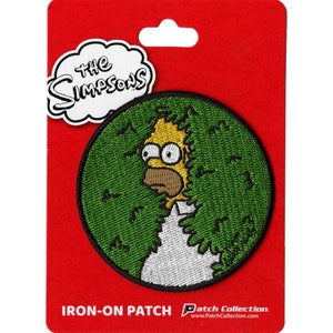 May include: Iron-on patch featuring a cartoon image of Bart Simpson peeking out from behind a bush. The patch is round and has a green background with the text "The Simpsons" in a white cloud above.