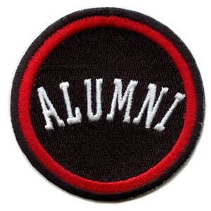 Puede incluir: Parche bordado circular con la palabra "ALUMNI" en blanco, con letras arqueadas. El parche tiene un fondo negro con un borde rojo y negro.