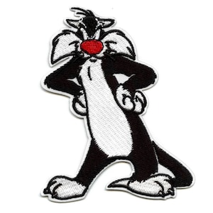 May include: Black and white embroidered iron-on patch of Sylvester the Cat from Looney Tunes. He is standing with his arms crossed and has a red nose.