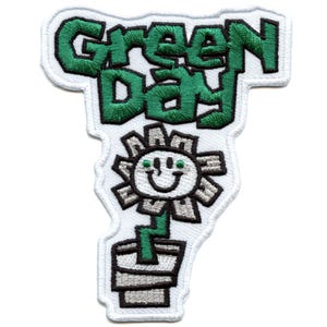 May include: Embroidered patch featuring the Green Day band logo, a green flower in a pot with a smiley face and green eyes.
