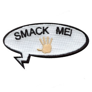 May include: White oval-shaped patch with black stitching and a black border. The patch has a white background with black text that reads "SMACK ME" and a tan handprint in the center.