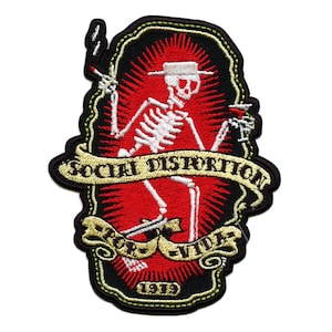 May include: Embroidered patch featuring a skeleton in a hat, holding a cigarette and a drink. The design includes the text "SOCIAL DISTORTION" and "POR VIDA 1979" on a red and black background with a yellow border.