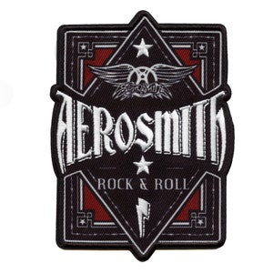 Könnte beinhalten: Schwarzer und weißer gestickter Patch mit dem Bandnamen "Aerosmith" in einer stilisierten Schriftart. Der Patch zeigt ein geflügeltes Logo mit einem Stern und die Worte "Rock & Roll" in einem roten Banner.