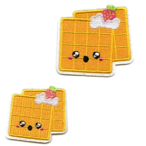 May include: Two yellow embroidered waffle patches with a cute cartoon face and a pink strawberry on top. The patches have a white outline.