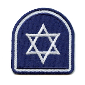 May include: A blue fabric patch with a white Star of David in the center. The patch has a white border.