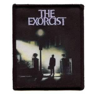 Könnte beinhalten: Ein schwarzer und weißer gestickter Aufnäher mit dem Text "THE EXORCIST" in weiß. Der Aufnäher zeigt die Silhouette von zwei Personen, die nachts auf einer Straße gehen.