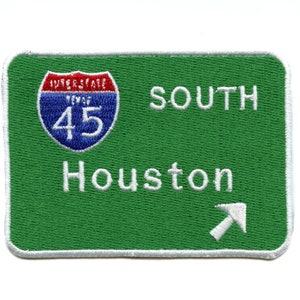 May include: Green highway sign with white text and a white arrow pointing to the right. The sign reads "Interstate 45 South Houston".