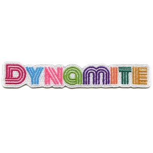 May include: A colorful embroidered patch with the word "DYNAMITE" in a retro style font. Each letter is a different color, including pink, blue, green, purple, orange, and yellow.