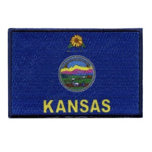 May include: A blue patch with a white circle containing a sunflower and the words "Ad Astra Per Aspera" and a smaller circle containing a landscape with a rainbow and the words "Kansas" in yellow letters.