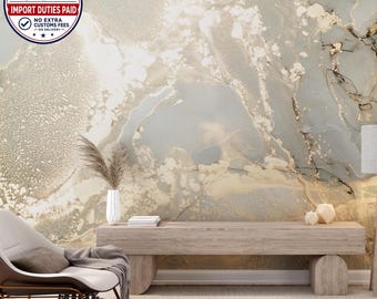 May include: A wall mural featuring an abstract fluid art design in shades of grey, white, and gold. A light wood bench sits in front of the wall, holding a white vase with dried grass, a stack of books, and two geometric candle holders.