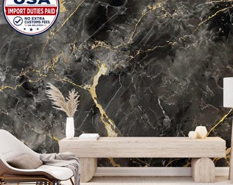 May include: A wall mural featuring a black marble pattern with prominent gold veining. The scene includes a light-colored wooden bench, a white vase with dried pampas grass, and a white armchair with a gray throw blanket draped over it.