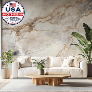 Può includere: Un murale con un motivo in marmo bianco e venature marroni. La scena include un divano bianco con cuscini, un tavolino rotondo in legno, due piante verdi in vaso e un badge circolare con il testo USA IMPORT DUTIES PAID.