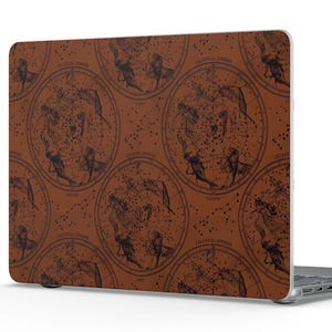 May include: A laptop featuring a dark brown skin with a repeating pattern of circular celestial star charts. The design includes intricate black line illustrations of constellations and astronomical symbols printed across the entire surface.