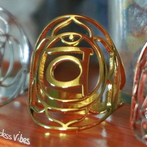 Puede incluir: Tres anillos de plata, oro y oro rosa con un diseño de símbolo de chakra. Los anillos están todos abiertos y tienen un diseño delicado e intrincado.