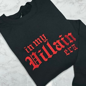 May include: Black sweatshirt with red embroidered text that reads "in my Villain era".