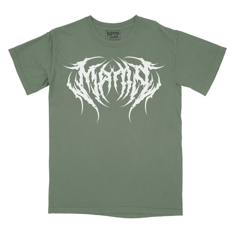 Może przedstawiać: Zielony t-shirt z białym nadrukiem słowa "MEGADETH" w stylizowanym foncie.