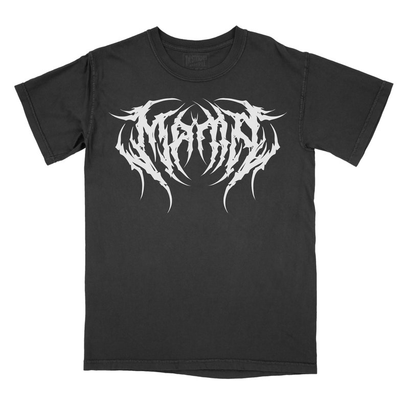 Może przedstawiać: Czarny T-shirt z białym nadrukiem słowa "MAYHEM" w stylizowanym metalowym foncie.
