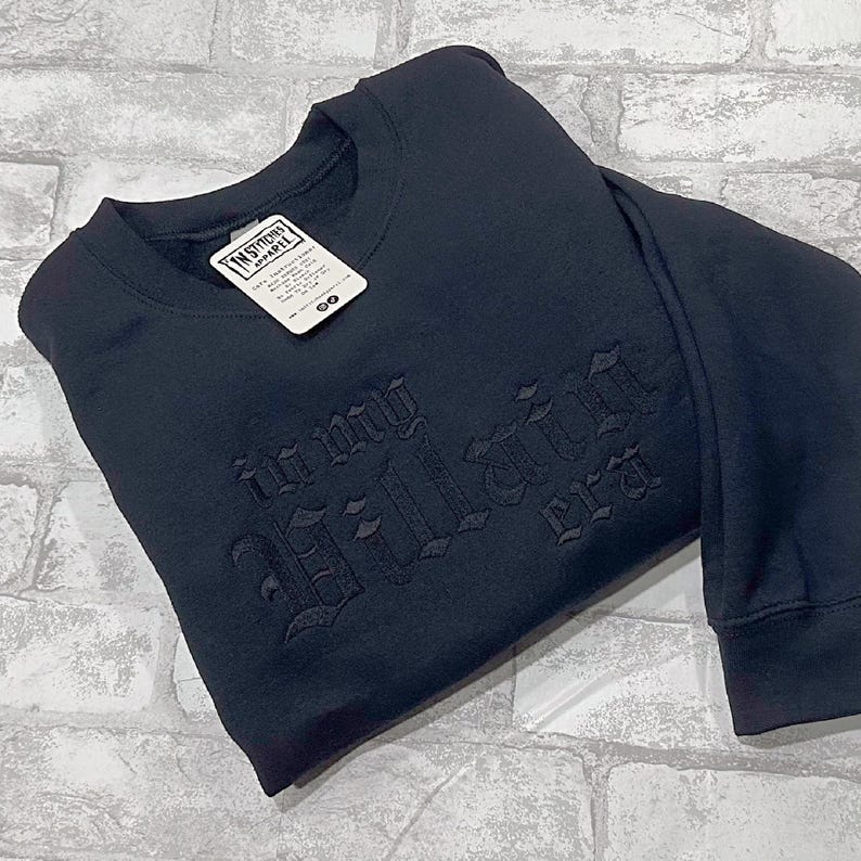 May include: Black sweatshirt with the words "Young Villain Era" embroidered in a gothic font.