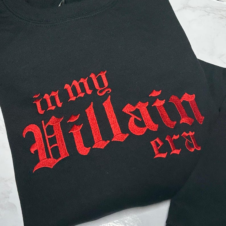 May include: Black sweatshirt with red embroidered text that reads "in my Villain era".