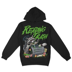May include: Black hooded sweatshirt featuring a graphic of a raccoon reading a book in a bin. The text "Reading Trash" is printed in green on the front of the sweatshirt.