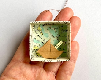 Origami sailboat in a small paper box with a world map motif, personalized paper boat with custom text