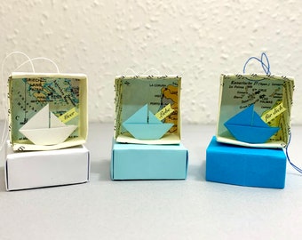 Origami sailboat in a small paper box with a world map motif, personalized paper boat with custom text