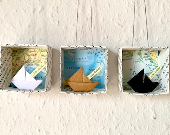 Origami sailboat in a small paper box with a world map motif, personalized paper boat with custom text
