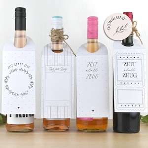 May include: Four wine bottles with decorative tags. The tags are white with black text and designs, including floral wreaths and geometric patterns. The bottles have different colored caps and wine inside.
