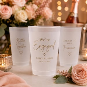 Peut inclure: Trois gobelets en plastique dépoli avec du texte doré. Le gobelet central affiche 'We're Engaged', 'EMILY & JAMES' et '06.15.2025'. Le gobelet de gauche indique 'Better Together' et celui de droite 'CHEERS TO OUR Forever', chacun avec un petit cœur.