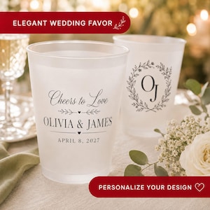 May include: Two frosted plastic cups featuring black printed text and graphics. The front cup displays the text Cheers to Love, OLIVIA & JAMES, and APRIL 8, 2027. The back cup features a circular botanical wreath design with the initials OJ.