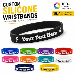 Può includere: Un braccialetto in silicone nero con il testo bianco Your Text Here affiancato da due icone a forma di fulmine, mostrato insieme a una collezione di braccialetti di vari colori tra cui blu, verde, viola, rosso, rosa, arancione, turchese, bianco e giallo.