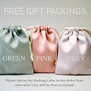 May include: Three drawstring bags in green, pink, and grey. The bags are made of a soft, fabric-like material. The text "FREE GIFT PACKINGS" is at the top of the image. The text "Please Advise the Packing Color in the Order Note otherwise Grey will be Sent as Default" is at the bottom of the image.