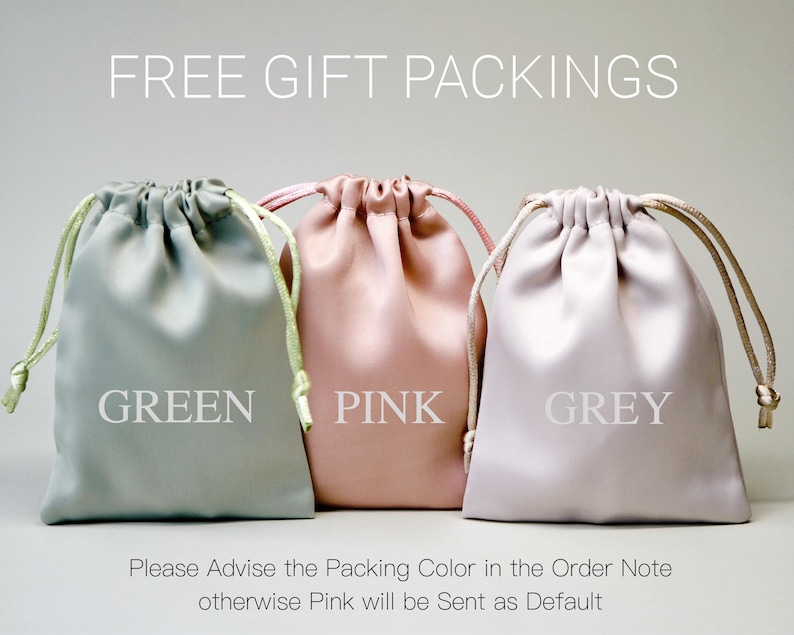 May include: Three satin drawstring gift bags in green, pink, and grey. The bags are labelled with their respective colours. The text "FREE GIFT PACKINGS" is at the top of the image.
