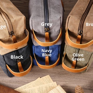 Puede incluir: Seis neceseres de diferentes colores: beige, gris, marr&oacute;n, negro, azul marino y verde oliva. Cada neceser tiene una cremallera y un asa de cuero.