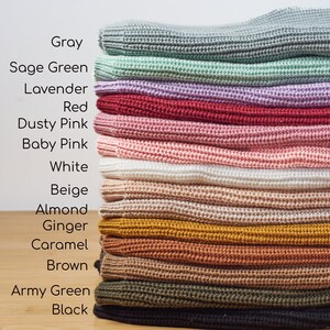 May include: A stack of knitted fabric in various colors, including gray, sage green, lavender, red, dusty pink, baby pink, white, beige, almond, ginger, caramel, brown, army green, and black. The text on the left lists the colors.