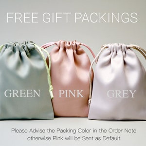 Op de afbeelding: Drie trekkoordzakjes in groen, roze en grijs. De zakjes zijn gemaakt van een zacht, stofachtig materiaal. De tekst "FREE GIFT PACKINGS" staat bovenaan de afbeelding. De tekst "Please Advise the Packing Color in the Order Note otherwise Pink will be Sent as Default" staat onderaan de afbeelding.