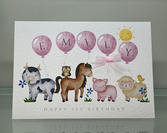 Puede incluir: Tarjeta de felicitación con una ilustración en acuarela de animales de granja y globos que deletrean "EMILY". La tarjeta presenta una vaca, un búho, un caballo, un cerdo y una oveja, con un sol. El texto dice "HAPPY 1ST BIRTHDAY".
